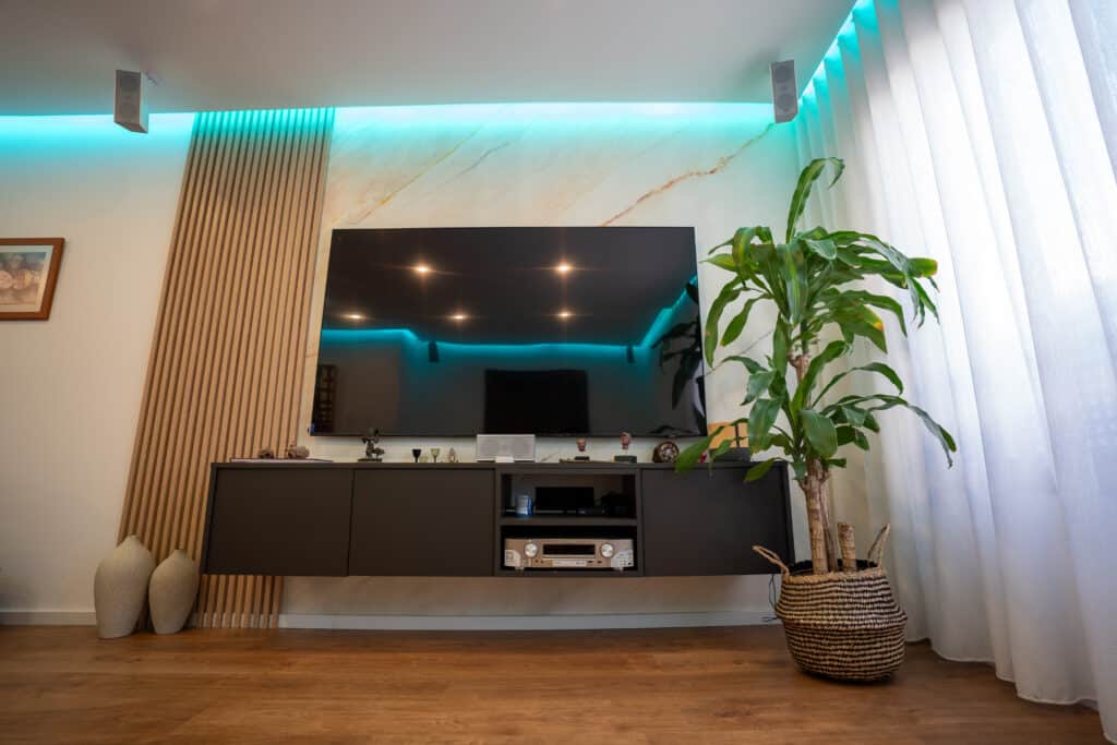 Mueble de salón volado con televisión en pared, decoración, LED azules en techo, altavoces home cinema
