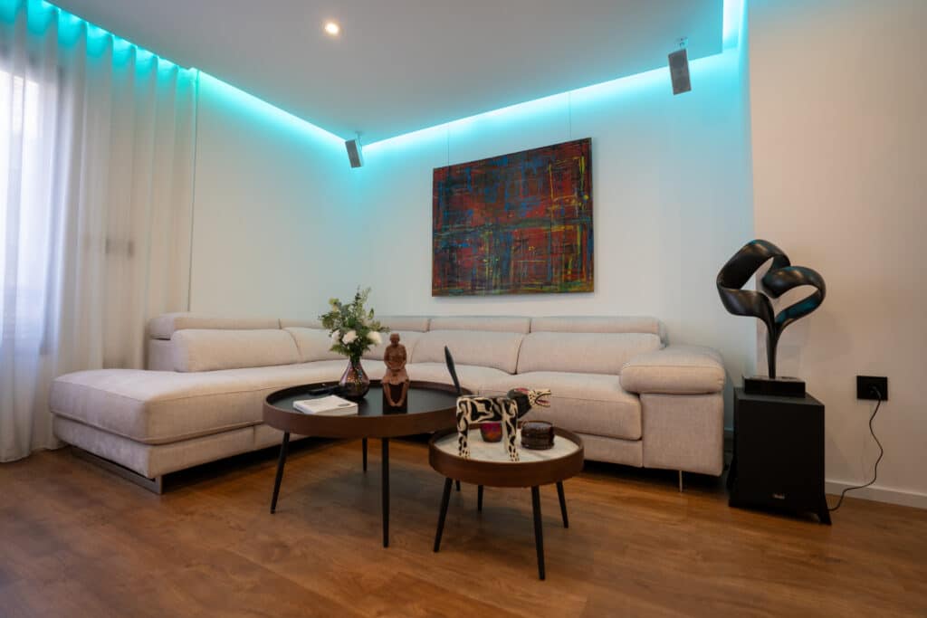 Salón con sofá esquinero, decoración e iluminación LED