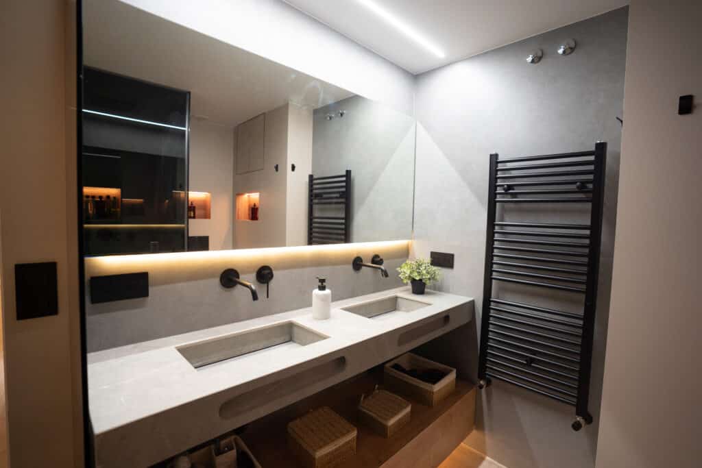 Baño con gran espejo y doble lavabo con iluminación LED