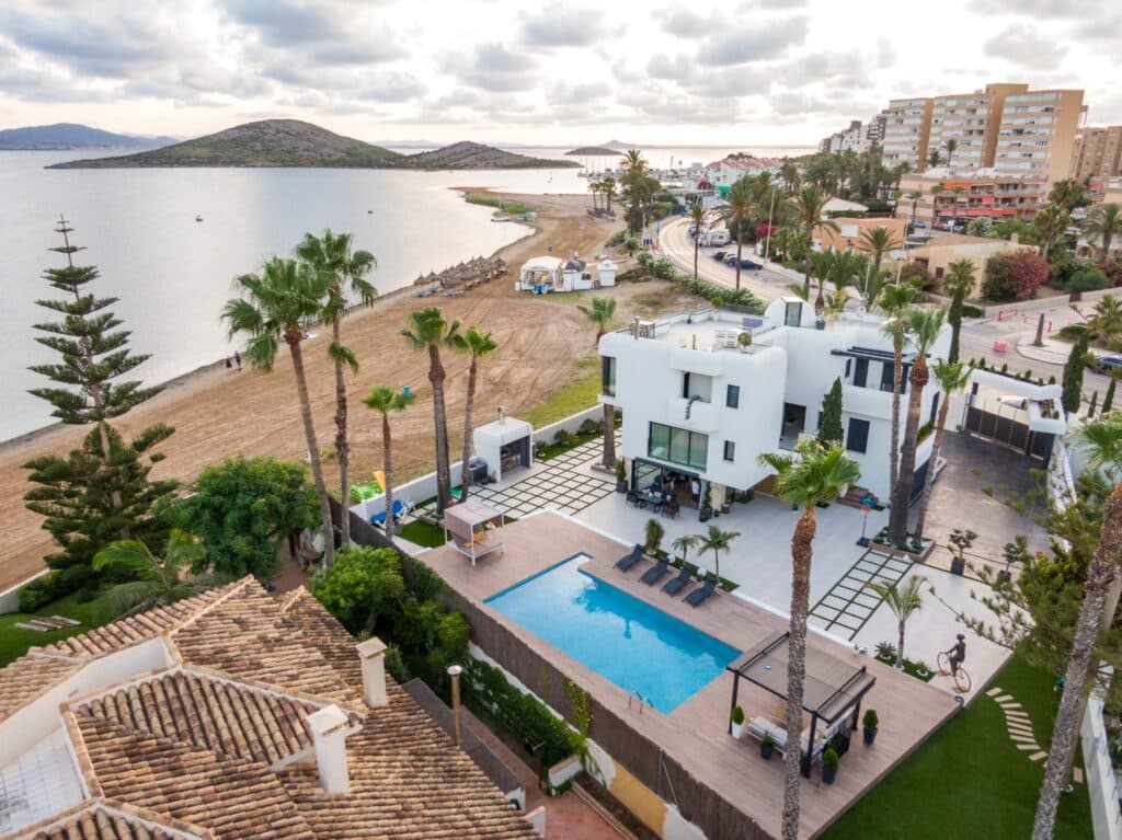Panorámica de chalet en la playa en Mar Menor con palmeras, piscina, zona aparcamiento