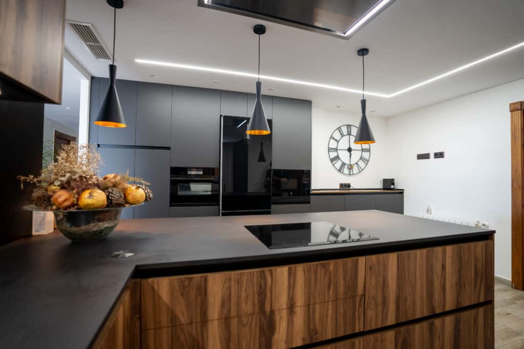 Cocina moderna y elegante en tonos oscuros con electrodomésticos