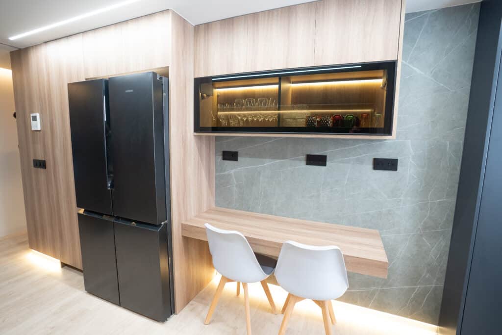 Cocina con mesa volada y frigorífico de cuatro puertas negro