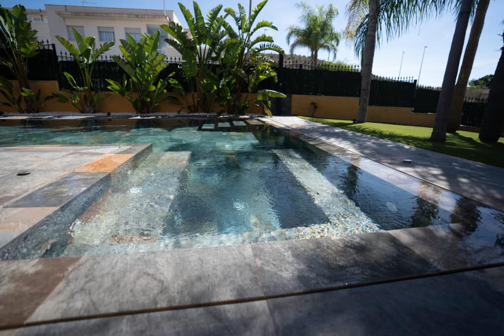 Agua de piscina en movimiento con palmeras de hoja ancha