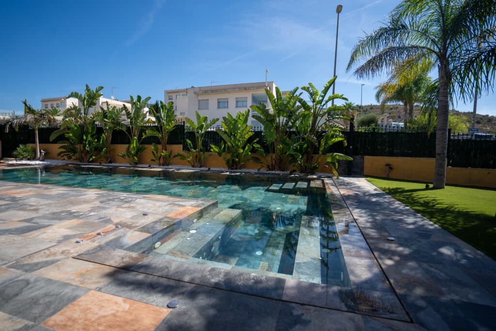 Jardín con piscina y palmeras